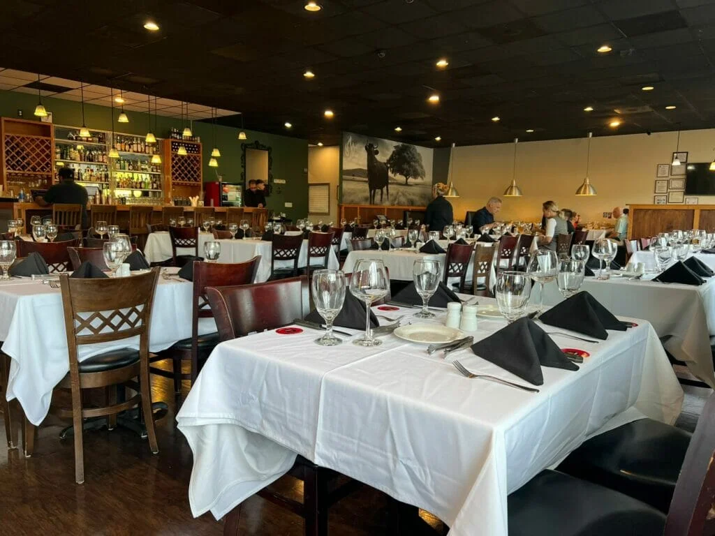 An empty Brazilian Steakhouse with tables and chairs.