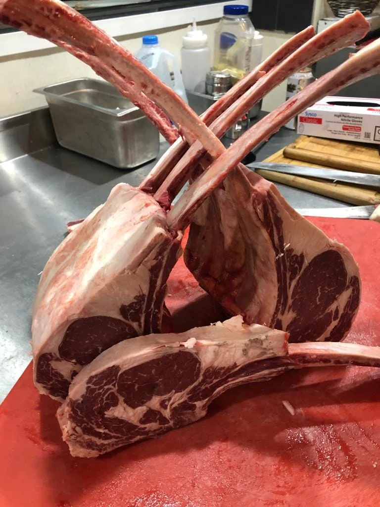 A pair of lamb ribs on a cutting board at a Churrascaria.